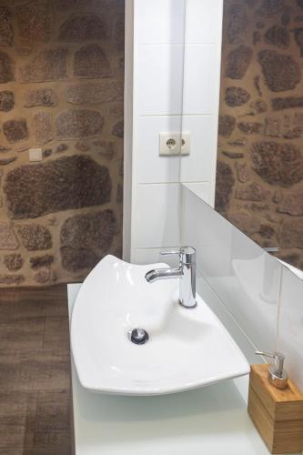 a bathroom with a white sink and a mirror at Casa da Cuca in Campo do Gerês