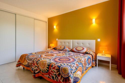 a bedroom with a large bed and a yellow wall at Campo Vecchio Kamerops et piscine in Ghisonaccia
