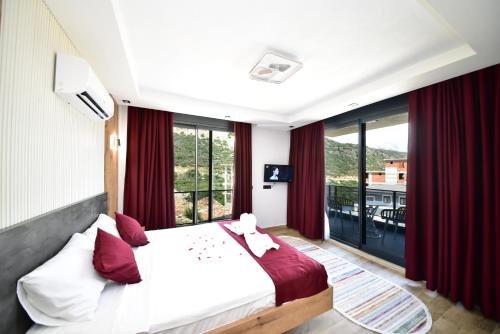 a bedroom with a large bed with red curtains at Villa Belmora Villa Asgora in Demre