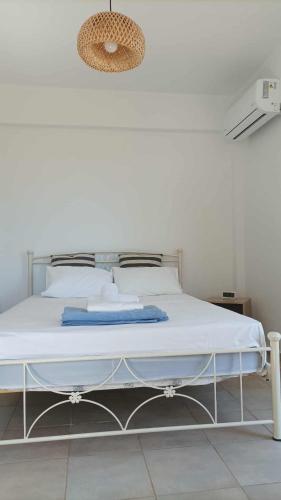 a white bed in a white room with at Andros Summer House II in Andros