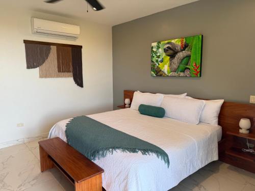 a bedroom with a bed with a picture on the wall at Hotel Las Lomas in Nandayure