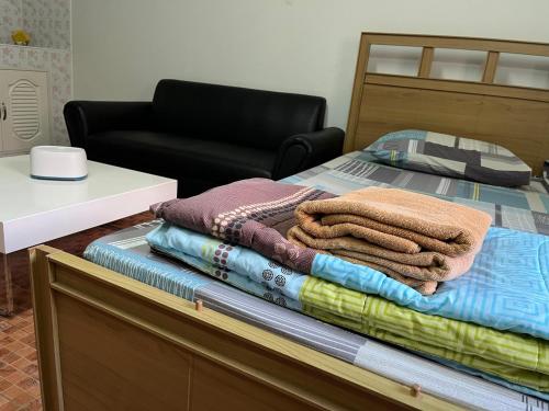 a pile of towels sitting on top of a bed at Impact Arena C9 by Jintana in Thung Si Kan