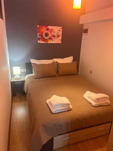 a bedroom with a bed with two towels on it at Апартамент Аксел in Panagyurishte