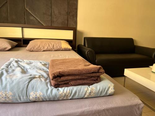 a room with a bed with a chair and towels at Impact Arena C9 by Jintana in Thung Si Kan