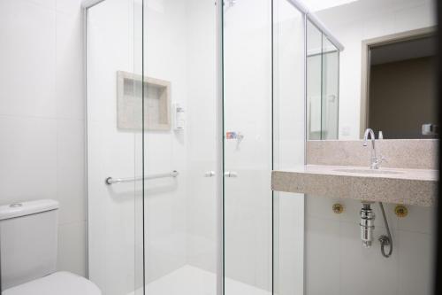 a bathroom with a shower and a toilet and a sink at Hotel Equinócios Express in Barcarena