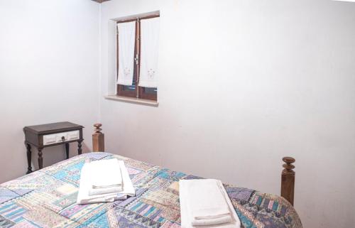 a bedroom with a bed with two towels on it at Casa dos Cobertos in Terras de Bouro