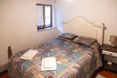 a bedroom with a bed with two towels on it at Casa dos Cobertos in Terras de Bouro