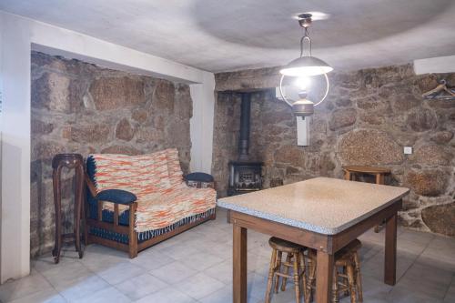 a room with a bed and a table and chairs at Casa dos Cobertos in Terras de Bouro