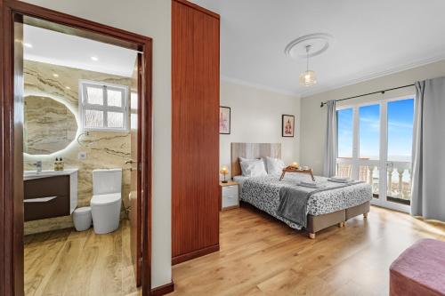 a bedroom with a bed and a bathroom at Cumbres Villa in Funchal