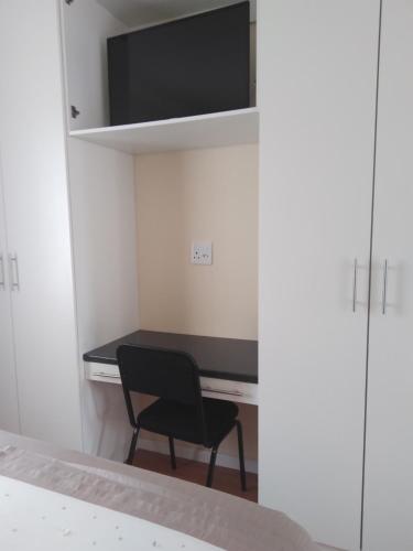 a room with a desk with a chair and a tv at Buliso Homestay in Amsterdamhoek