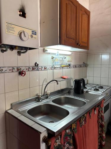 a kitchen with a sink and a stove at Complejo Alto Paraiso in Villa Cura Brochero