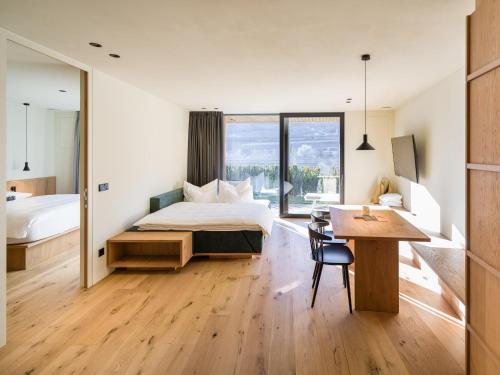 a bedroom with a bed and a desk and a table at Apartment Garden Loggia in Novacella