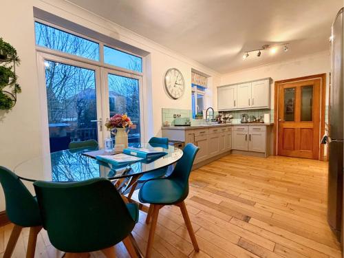 a kitchen with a table and chairs and a dining room at Private All-Weather Hot Tub House, Fire Pit, Free Parking, Near City Centre, Freeman Hospital, Great Transport Links in Longbenton