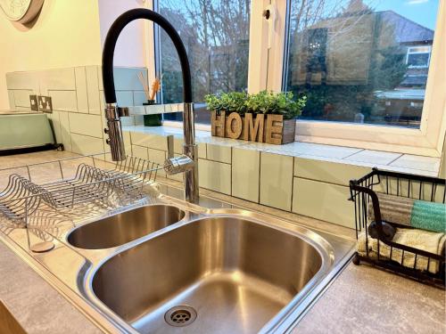 a kitchen sink in a kitchen with a window at Private All-Weather Hot Tub House, Fire Pit, Free Parking, Near City Centre, Freeman Hospital, Great Transport Links in Longbenton