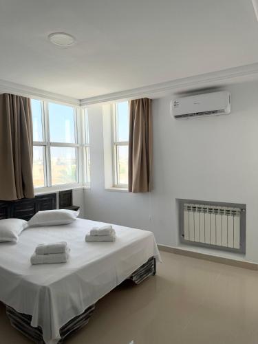 a bedroom with a large bed with two towels on it at Le charbon élégant in Bin Rhilouf