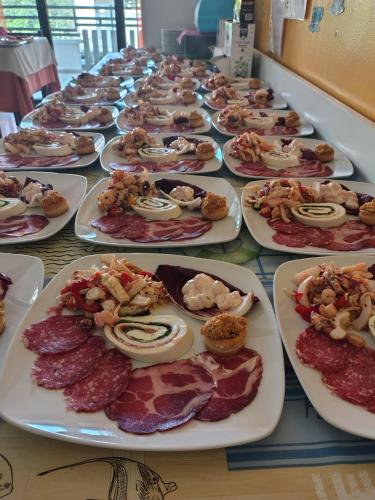 a long table with plates of food on it at Hotel Rosy in Bellaria-Igea Marina