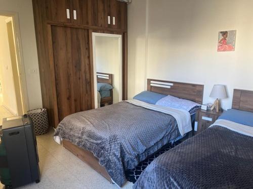 a bedroom with two beds and a mirror at Cozy appartment in hrajel in Dir‘alī