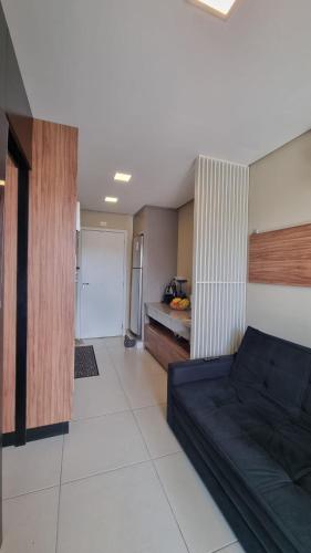 a living room with a couch and a kitchen at Studio Comfort apartament Arujá in Arujá