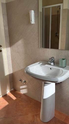 a bathroom with a white sink and a mirror at Casa Rasiglia 3 House Relax in Casenove