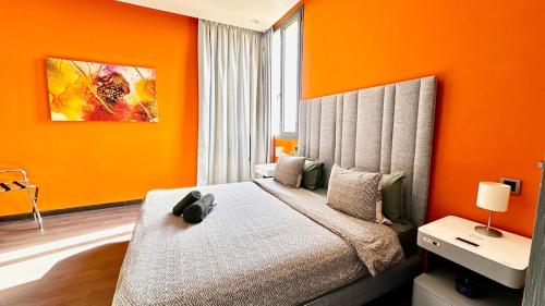 a bedroom with a bed with an orange wall at Cozy appartement Marrakech in Marrakesh