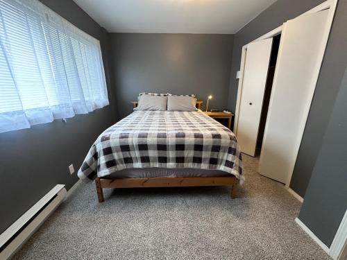 a bedroom with a bed with a checkered blanket at Texada Hunter Hiker friendly suite in Vananda