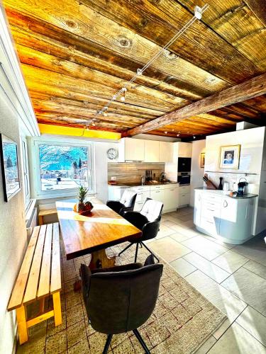 a kitchen with a wooden table and some chairs at Mountain View in Andermatt