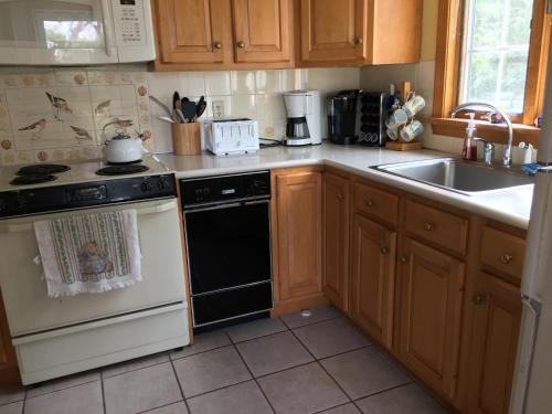 a kitchen with a stove and a sink at Bayside Bliss in Dennis