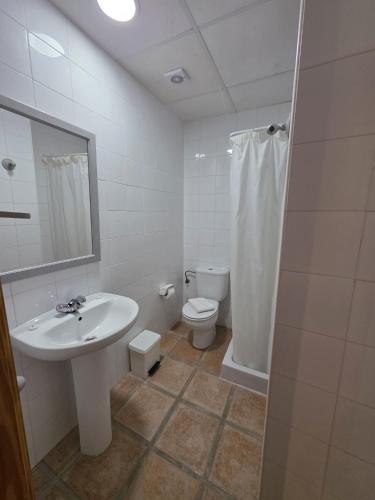 a white bathroom with a sink and a toilet at La Cilla Moratalla in Moratalla