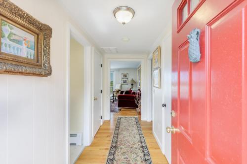 a hallway with a red door and a rug at Le Petit Château in Dennis