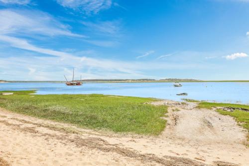 a beach with a boat in the water at Pleasant Point in Wellfleet
