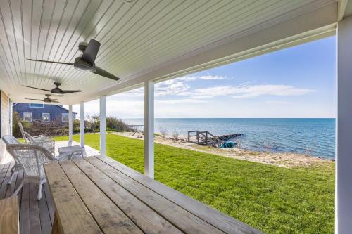 a porch with a table and chairs and the ocean at Sea Winds in Brewster