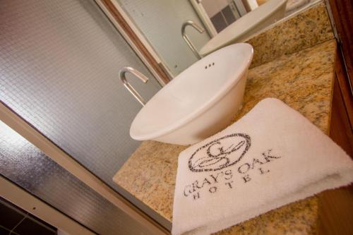 a bathroom with a toilet and a towel on a counter at Grays Oak Hotel in Athi River