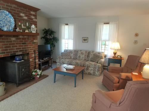 ein Wohnzimmer mit Sofa und Kamin in der Unterkunft Summer Sand in Dennis
