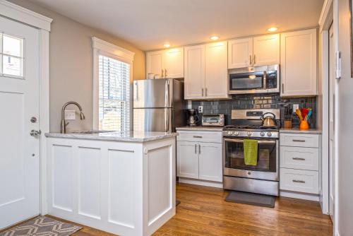 a kitchen with white cabinets and stainless steel appliances at Cod Hollow in Provincetown