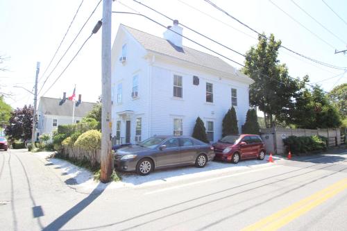 two cars parked in front of a white house at High Tide Lower Level in Provincetown