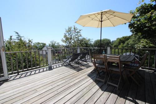 a wooden deck with a table and an umbrella at High Tide Upper Level in Provincetown