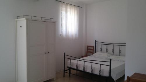 ein Schlafzimmer mit einem schwarzen Bett und einer Kommode in der Unterkunft Monolocale Lori in Montefalco