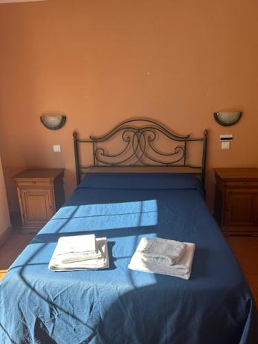 a blue bed with two towels on top of it at Hotel Cadalso - Casa Moncho in Cadalso de los Vidrios
