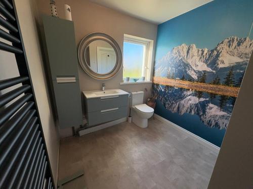 a bathroom with a sink and a mirror and a toilet at Shanawee in Gleneely