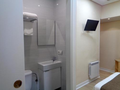 a small bathroom with a toilet and a sink at Pensión Urumea in San Sebastián