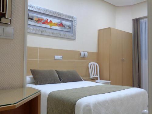 a hotel room with a bed and a desk at Pensi&oacute;n Urumea in San Sebasti&aacute;n