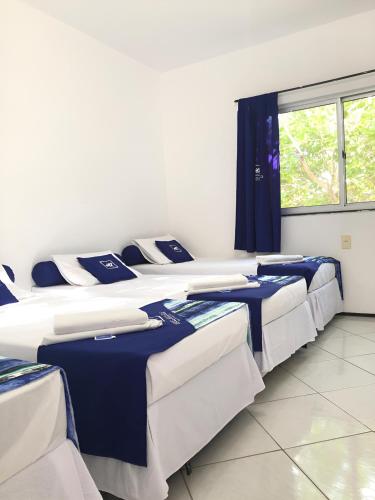 a row of beds in a room with a window at Hotel Arco-Íris in Itapipoca