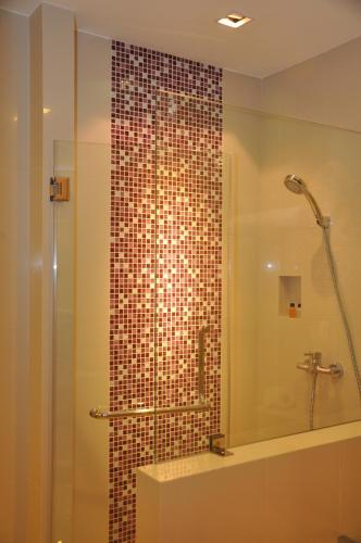 a bathroom with a shower with a glass door at Iyarin @ Tuk Chang Hotel in Bangkok