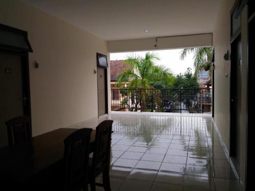 um quarto com uma mesa e cadeiras e uma varanda em K15 Exclusive em Malang