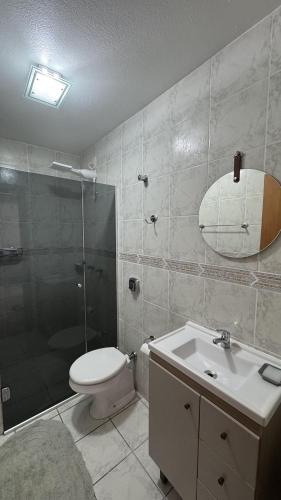 a bathroom with a toilet and a shower and a sink at Apto 2D ensolarado, sacada e garagem, centro in Nova Petrópolis