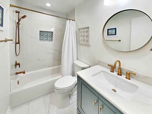 a bathroom with a sink toilet and a mirror at Lighthouse Point 25A in Tybee Island