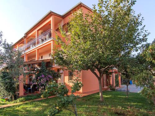an orange building with trees in front of it at Apartments Cvek in Rovinj