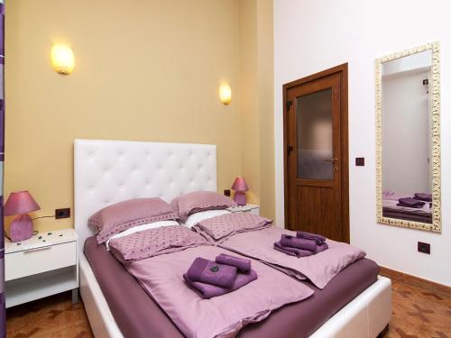 a bedroom with a large bed with purple pillows at Apartments Cvek in Rovinj