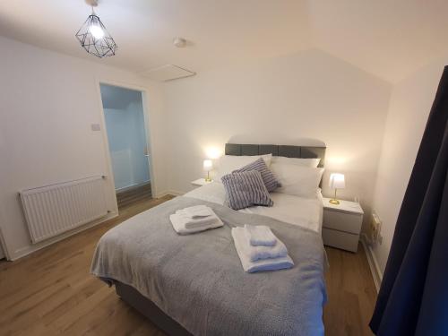 a bedroom with a large bed with towels on it at FLAT 2 Seven Cambrian Square First Floor Flat in Newtown