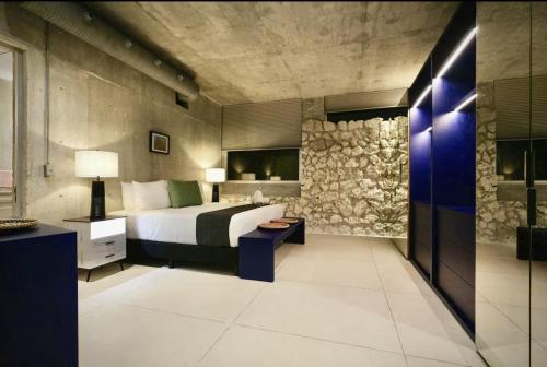 a bedroom with a bed and a stone wall at Casa Piedra Villa in Cancún